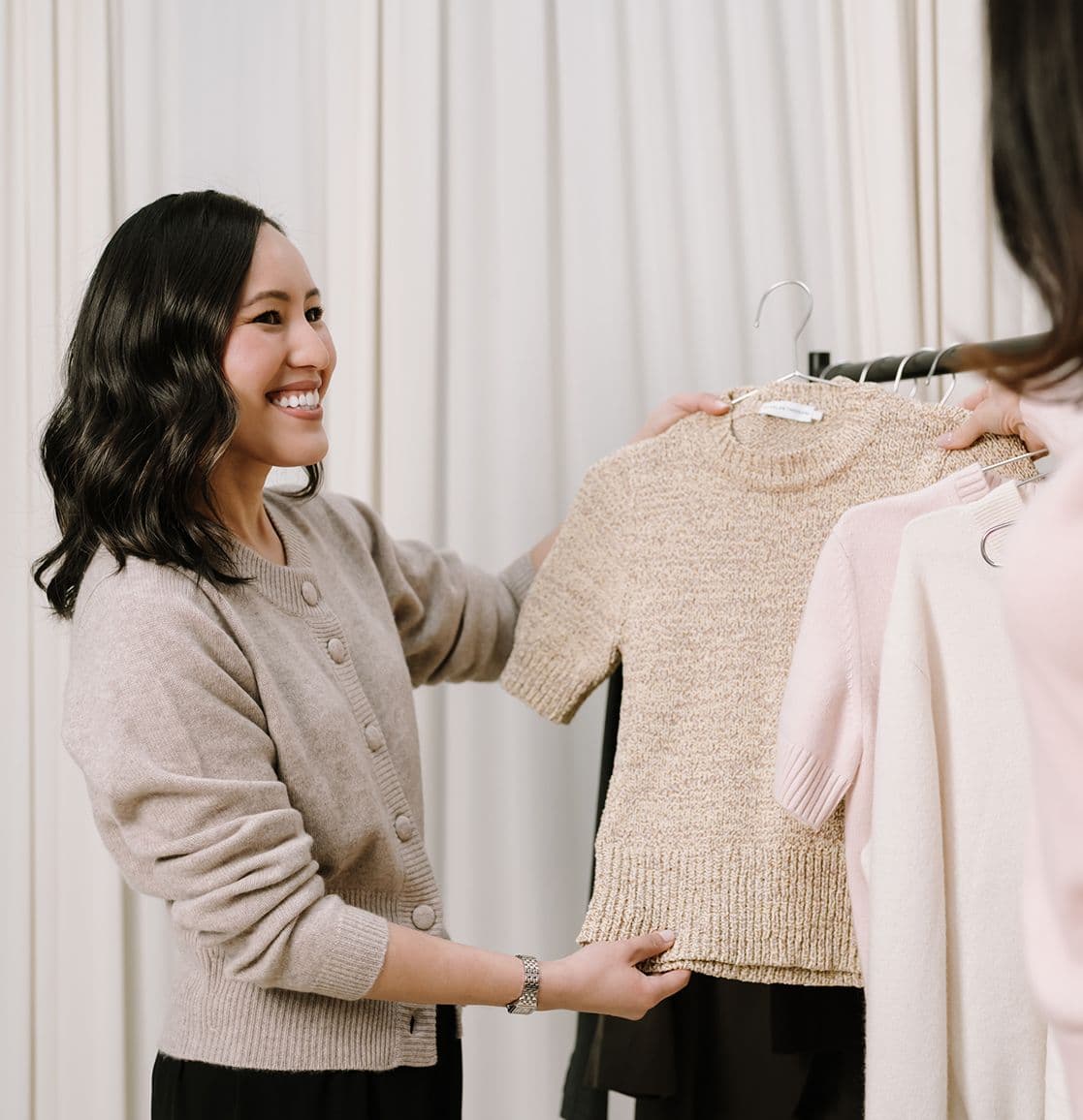 Gulinka hanging pale knitwear on a studio clothes rack