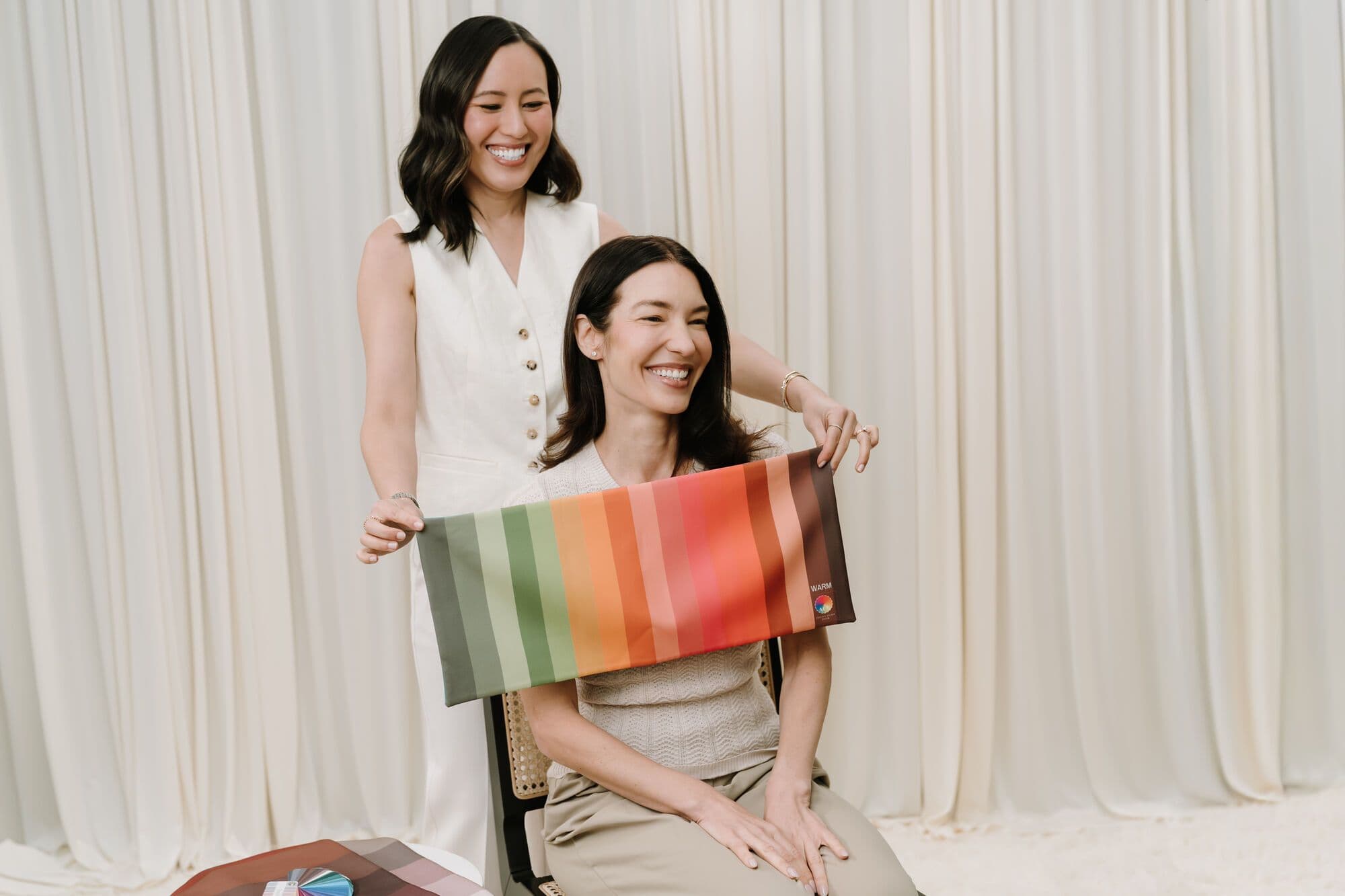 Gulinka draping a warm-toned colour swatch over a seated client
